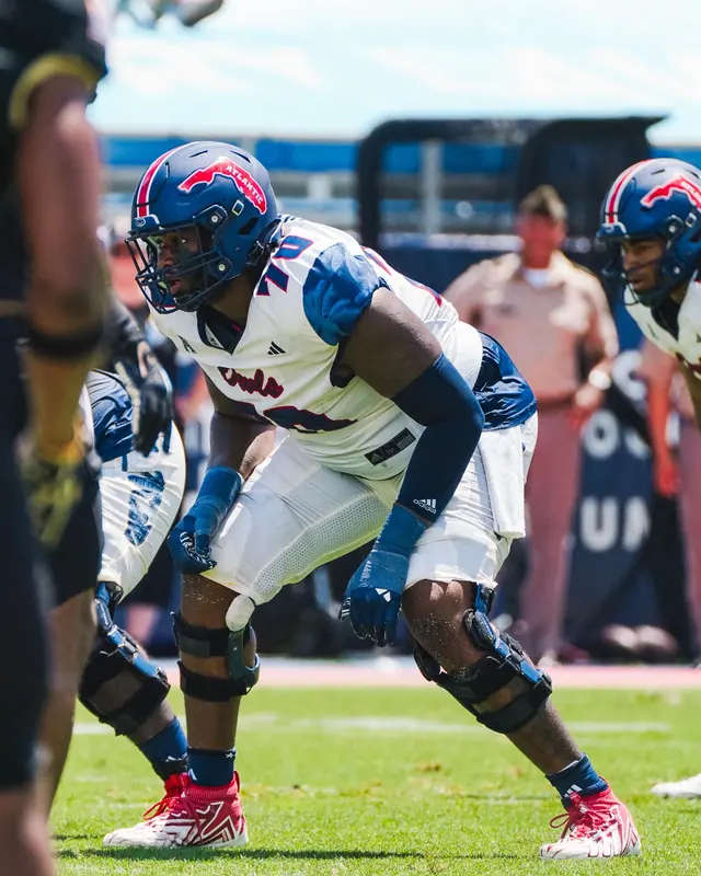Malcolm in a white Florida Atlantic jersey, set in his stance on the offensive line