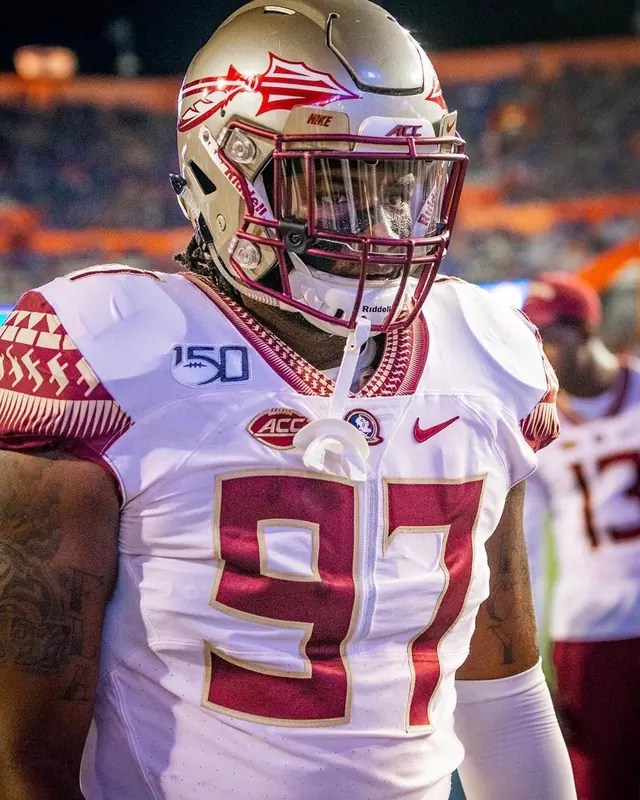 Malcolm in a white Florida State jersey, number 97, with a gold helmet